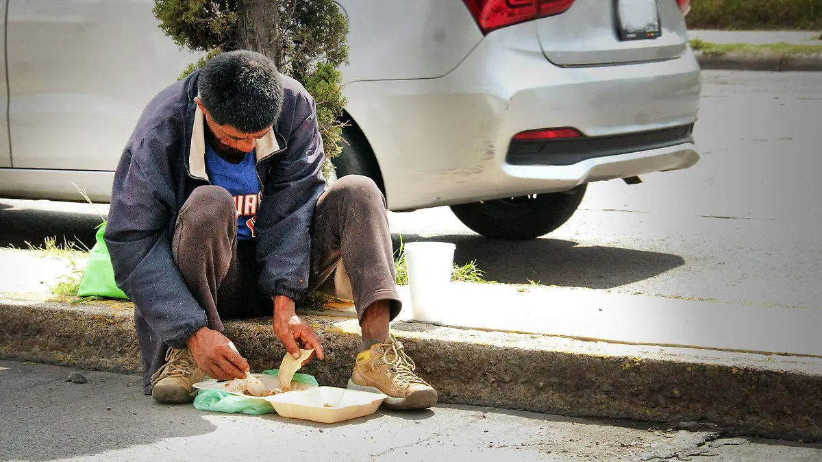 persona comiendo sentado en la banqueta